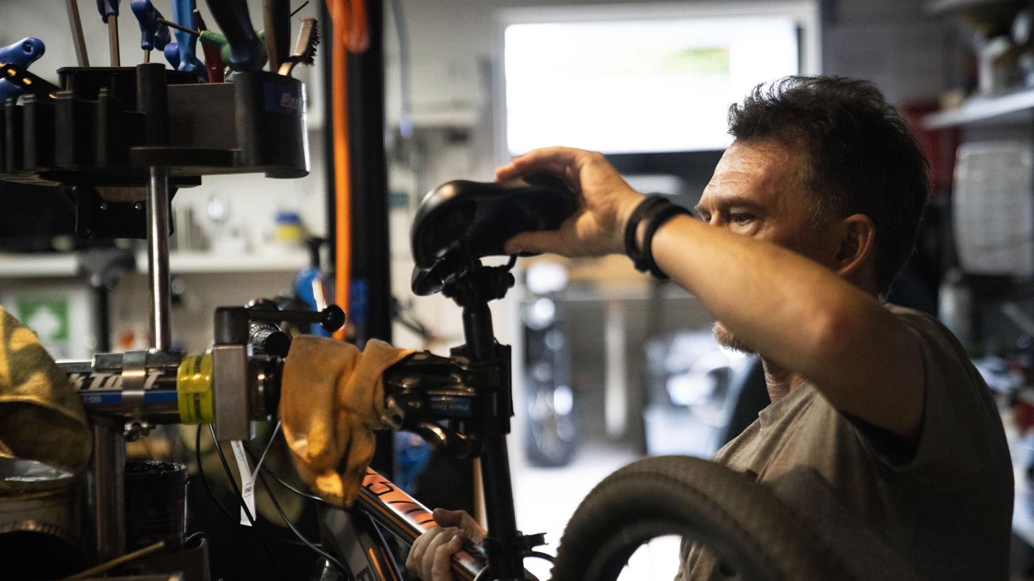 Byron Bay & Sydney Bike Bike Shop and Repairs, mechanic fixing a bike and adjusting the bicycle saddle.