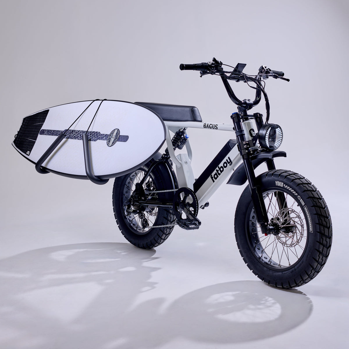 Fatboy electric bike with a surfboard carrier against a softly lit studio background