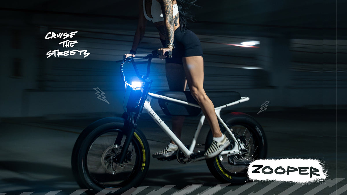 Rider on a silver ZOOZ ZOOPER at night with the headlight illuminated